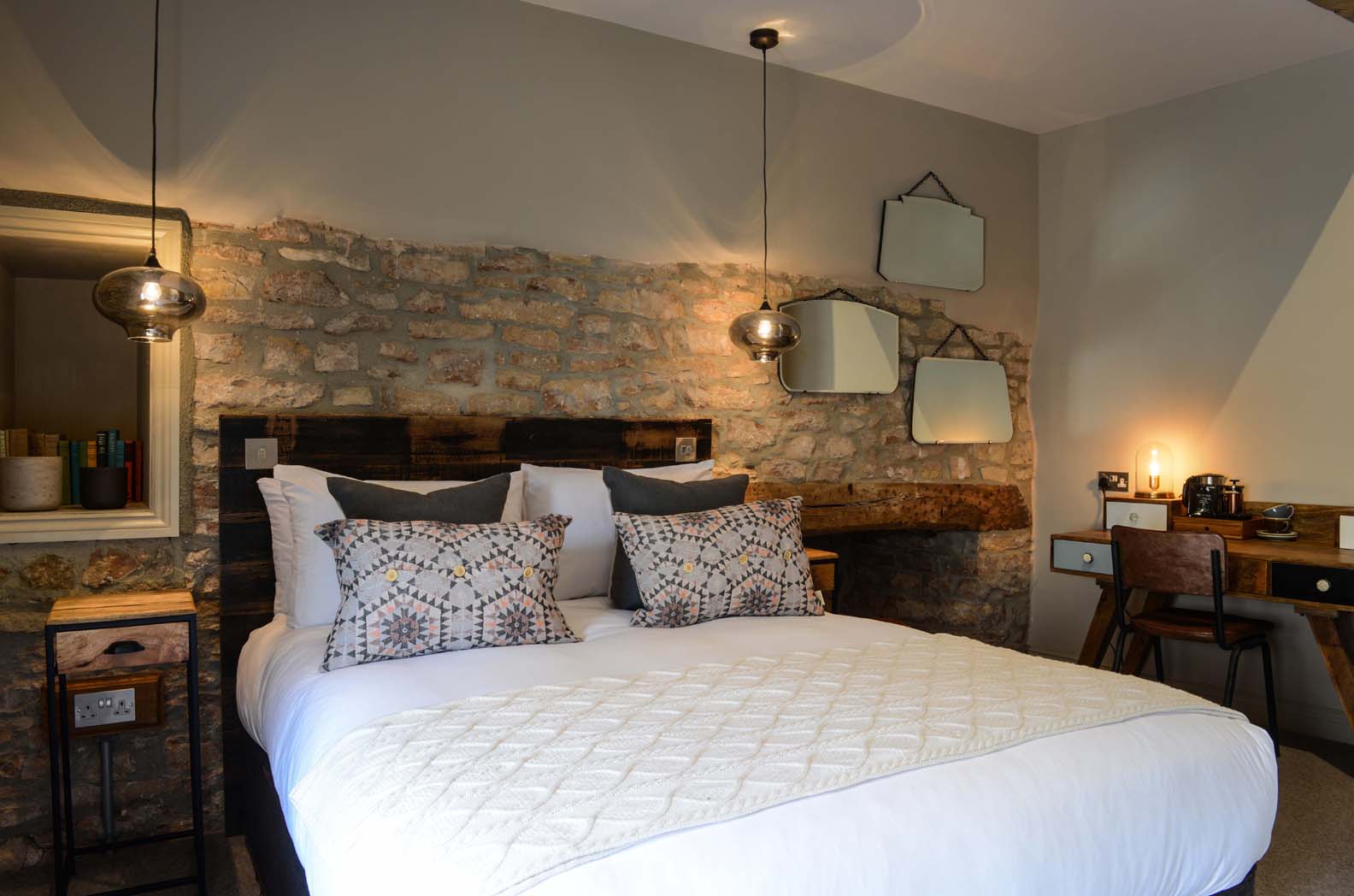 Greendown - Kingsize bedroom with white linen, stone wall feature, lamps and ambient lighting